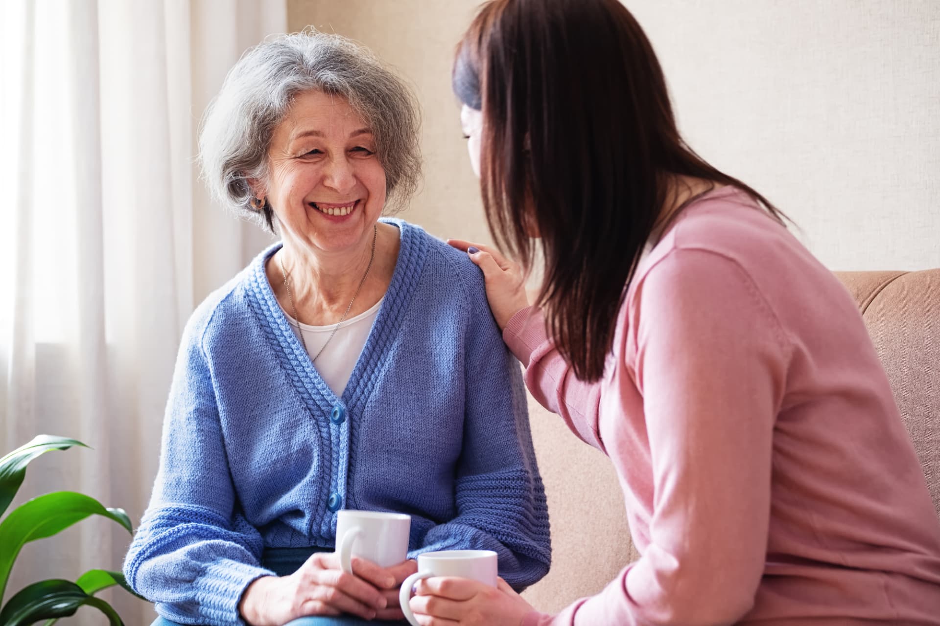 An older woman smiling while talking with a supportive family member